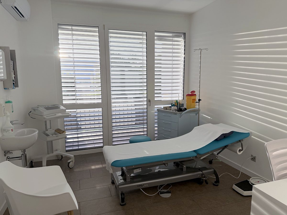 Examination room 1 with the couch, the ECG machine and the washbasin